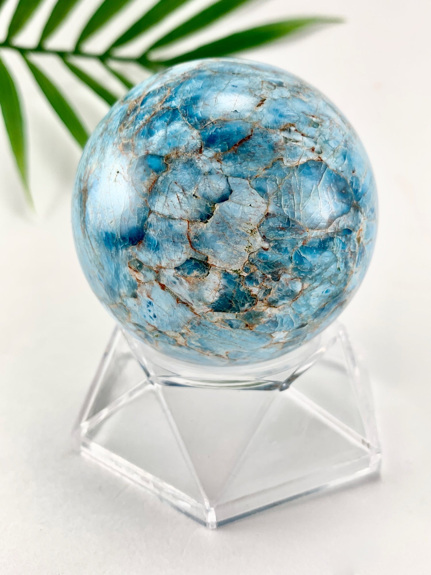 Blue apatite crystal sphere with swirling colors blue shades.